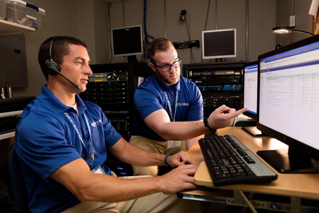 Photo of two people looking at computer screen